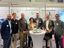 Gruppenbild mehrerer Personen, die vor einem Messestand stehen.